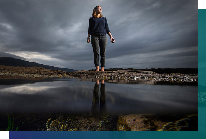 Researcher standing at the edge of a lake